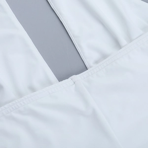 Detail of white halter neck dress featuring precise stitching and elastic fabric texture
