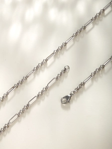 Close-up of a silver mixed link chain necklace with polished finish and lobster clasp