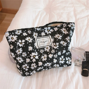 Detail of floral bubble cotton pouch featuring white daisy patterns and zipper closure