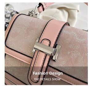 Detailed close-up of pink embossed fabric and silver metal buckle on elegant handbag