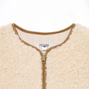 Minimalist cream sherpa fleece vest with gold zipper detail and adjustable waist