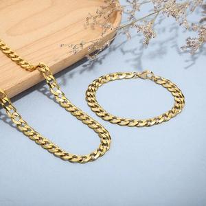 Set aus goldener Halskette und Armband aus Titanstahl im kubanischen Stil auf Holztablett