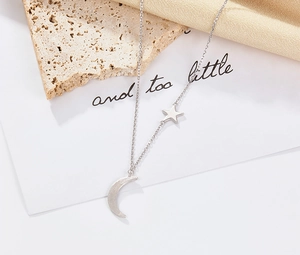 Detailed close-up of S925 silver star and moon pendants on a minimalist chain necklace
