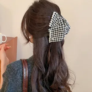Classic houndstooth fabric bow hair claw with elegant pearl edges for women back view