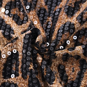 Macro detail of leopard print sequin fabric with high-density stitching for vests