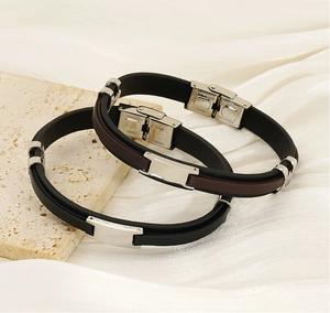 Detail of dual-layer leather bracelets with stainless steel clasps on a textured stone