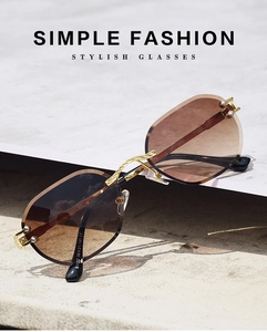 Close-up of rimless sunglasses featuring brown gradient lenses and gold engraved temples