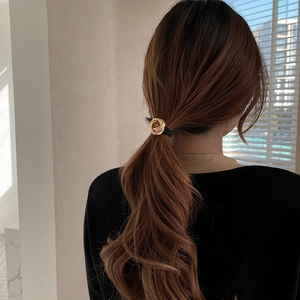 Elegant gold spiral geometric metal hair ring with black elastic band on ponytail
