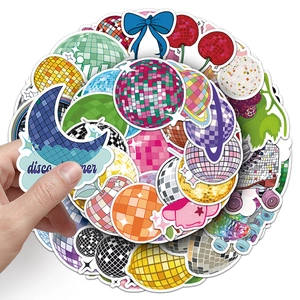 Macro shot of disco ball stickers in moon and fruit shapes with mosaic mirror textures