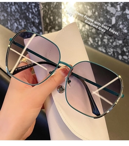 Detail of green and gold frame sunglasses with etched model number QF 7468 on temple