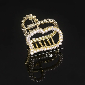 Detail of 4cm gold heart hair claw clip with white pearls and reflective shadow