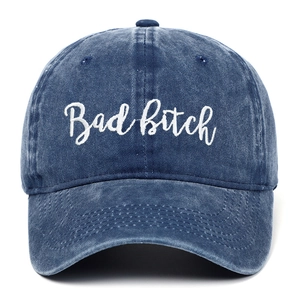 Detail of blue washed denim baseball cap with white Bad Bitch embroidery and stitching