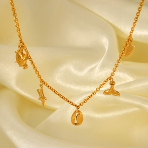 Detail of gold ocean pendants including sea turtle and starfish on a silk surface