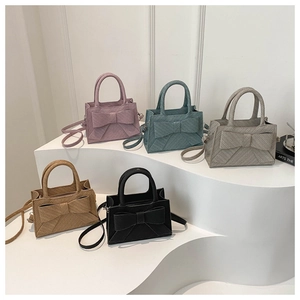 Variety of crossbody bow bags in pink, teal, grey, brown and black with top handles