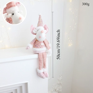 Pink Christmas doll with sequins sitting on a fireplace with warm lights, 50cm tall
