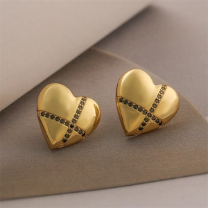 Detailed macro view of 18K gold plated heart earrings with black zircon cross patterns