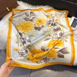 Gros plan détaillé d'un foulard en soie à fleurs avec des bordures orange vif