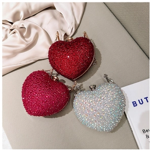 Detailed view of heart-shaped evening clutch bags with sparkling rhinestones and metal chain