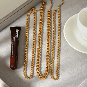18K gold plated stainless steel Figaro and curb chain necklaces on a jewelry tray