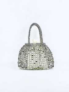 Detailed close-up of silver sequin woven handbag with white drawstring inner pouch