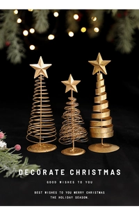 Macro shot of gold spiral Christmas tree ornaments with star toppers on a dark background