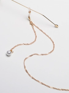 Detail of gold chain sunglasses strap with white pearls and anti-slip rubber loops