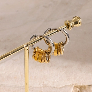 Vue macro des boucles d'oreilles rondes bicolores en acier inoxydable or et argent
