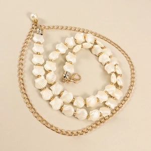 Autumn gold metal waist chain with shell beads and pearl pendant on beige background