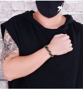 Detail of colorful and black plated titanium steel Cuban chain bracelet on male wrist