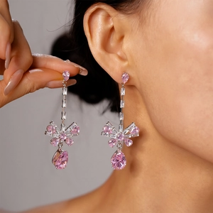 Close-up of pink zircon bow tassel earrings worn by a model to show elegant drape and scale