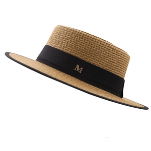 Détail du chapeau de paille plat avec ruban noir et boucle métallique dorée M