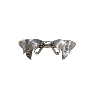 Silver bow-shaped metal hair clip with a vintage textured finish and ribbon design