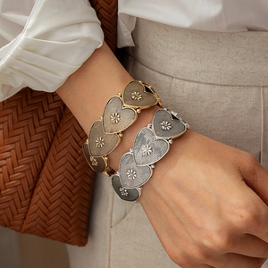 Vintage heart flower linked bracelet in gold and silver finish worn with casual attire