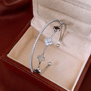 Detailed close-up of a double-layer silver clover bangle with shimmering zircon stones
