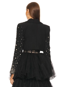 Detail of beaded sleeve on black cropped blazer paired with layered tulle dress back view