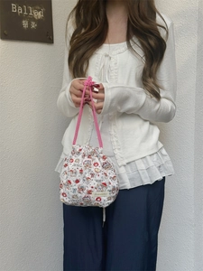 Close-up of quilted drawstring pouch with colorful cartoon prints and pink handles