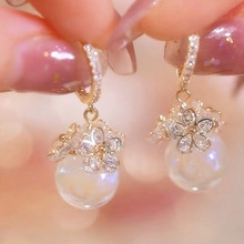 Macro shot of rose gold floral earrings featuring shimmering aurora beads and zircons