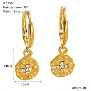 Detail of gold 18k plated stainless steel hoop earring with starburst zircon pendant