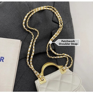 Détail du sac matelassé blanc avec poignée dorée et bandoulière en chaîne métallique