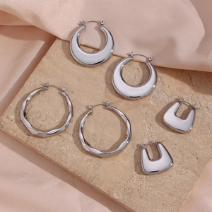 Three pairs of silver hollow hoop earrings with polished mirror finish on a stone base