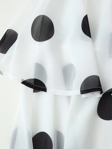 Detailansicht aus weißem Chiffonstoff mit schwarzen Punkten und Rüschendetails