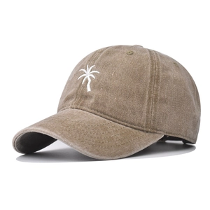 Close-up of vintage washed khaki cotton fabric and white palm tree embroidery on baseball cap