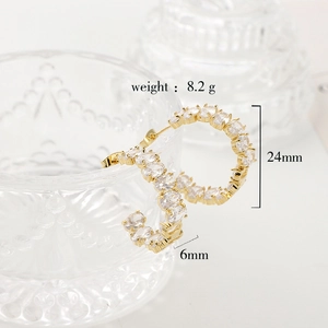Detailed view of C-shaped gold earrings with zircon including weight and size specs