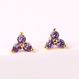 Macro shot of purple cubic zirconia stud earrings with gold plating in a trio cluster