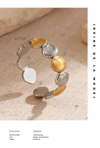 Detail of seashell ring featuring gold and silver two-tone texture on sand background