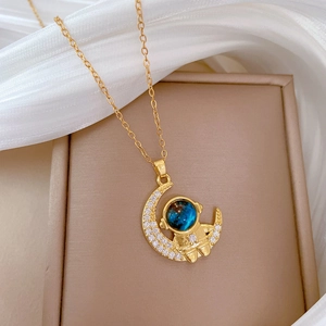 Golden astronaut and moon necklace with pavé crystals and a blue planet gemstone charm