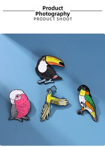 Detailed view of four colorful enamel parrot and toucan bird pins on blue background