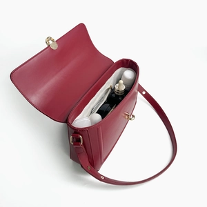 Overhead view of red leather handbag interior showing main compartment and zipper pocket