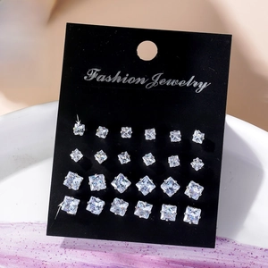 Detail of 12 pairs of square zircon stud earrings set on a black display card