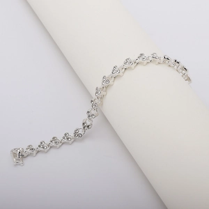 Detailed close-up of silver-tone clover link bracelet with embedded cubic zirconia stones